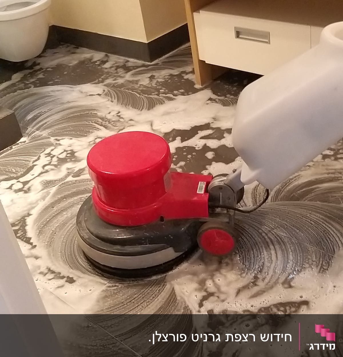 מכונת ניקוי אדומה עם סבון על רצפת חדר אמבטיה